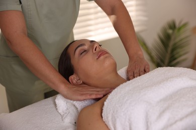 Photo of Young woman receiving massage in spa salon