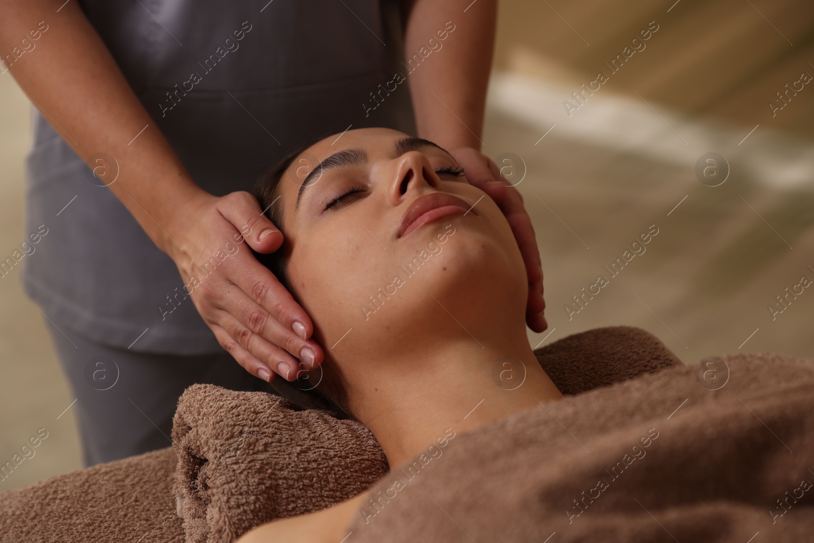 Photo of Young woman receiving massage in spa salon