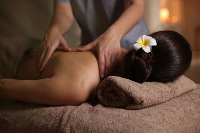 Woman receiving back massage in spa salon