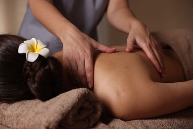 Woman receiving back massage in spa salon, closeup