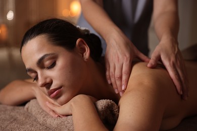 Photo of Woman receiving back massage in spa salon