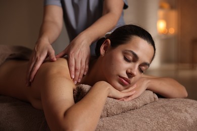 Photo of Woman receiving back massage in spa salon