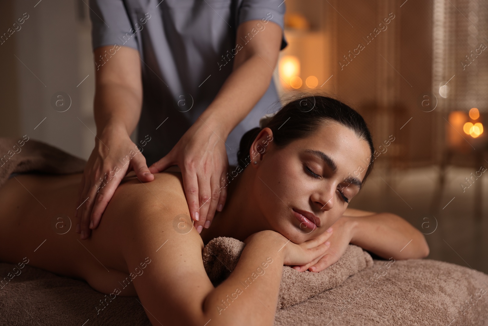 Photo of Woman receiving back massage in spa salon