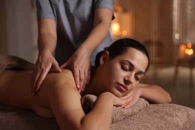 Photo of Woman receiving back massage in spa salon