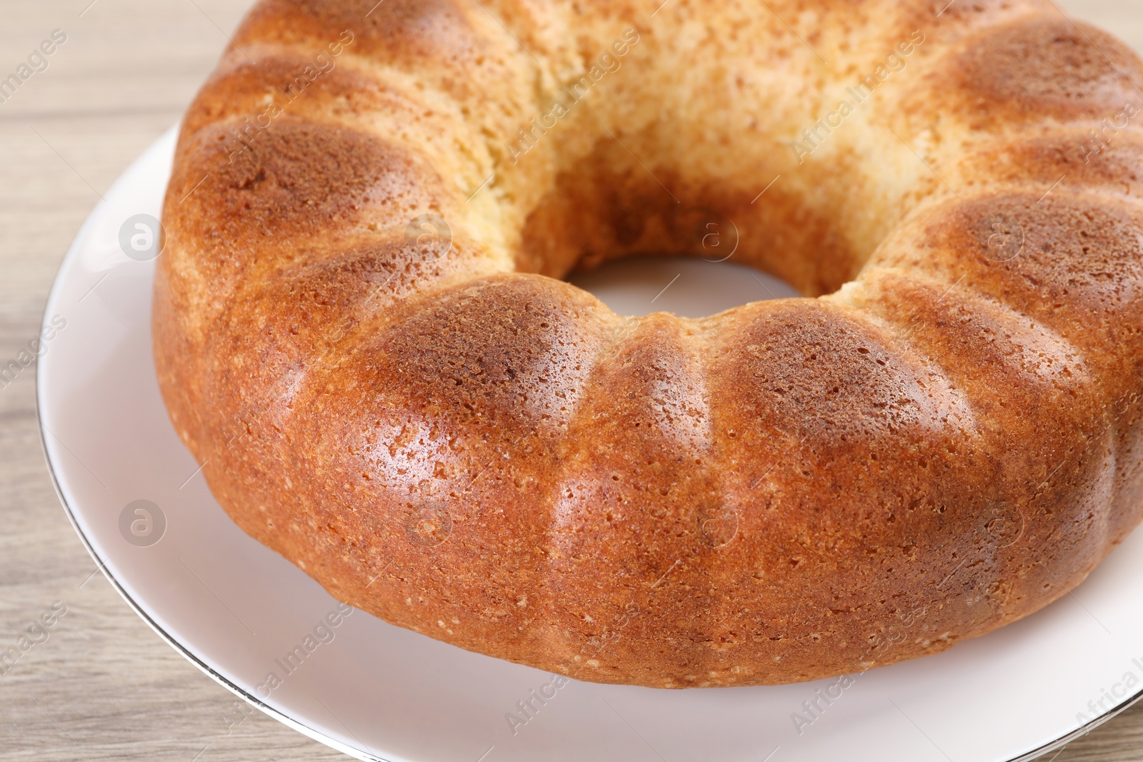 Photo of Freshly baked sponge cake on wooden table, closeup