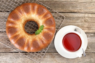 Photo of Freshly baked sponge cake and tea on wooden table, top view