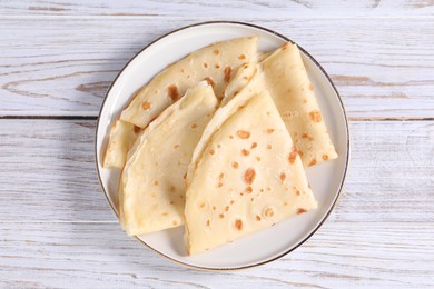 Photo of Delicious folded crepes on wooden rustic table, top view