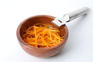 Photo of Fresh orange zest in bowl and zester tool isolated on white