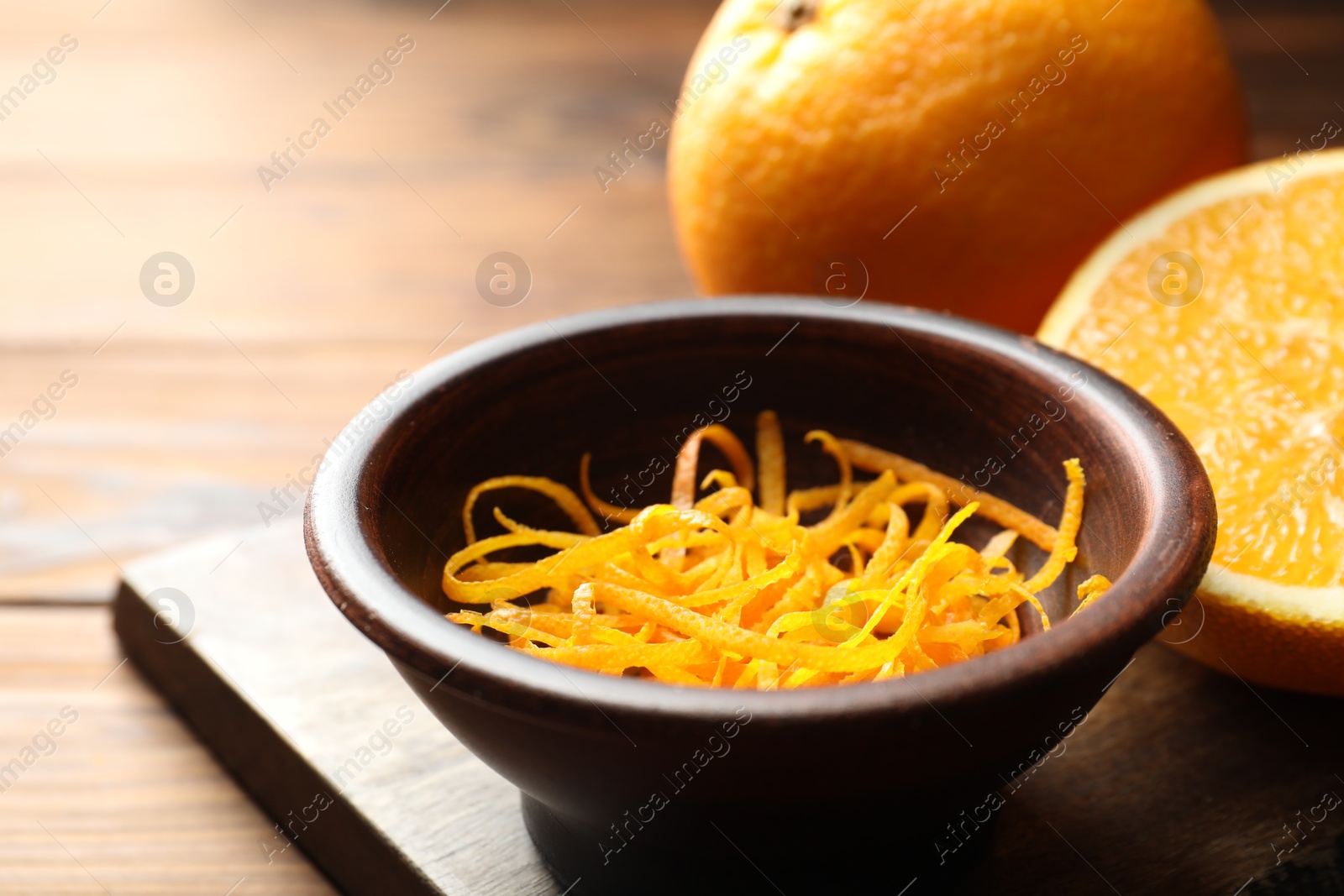 Photo of Orange zest and fresh fruits on wooden table, closeup