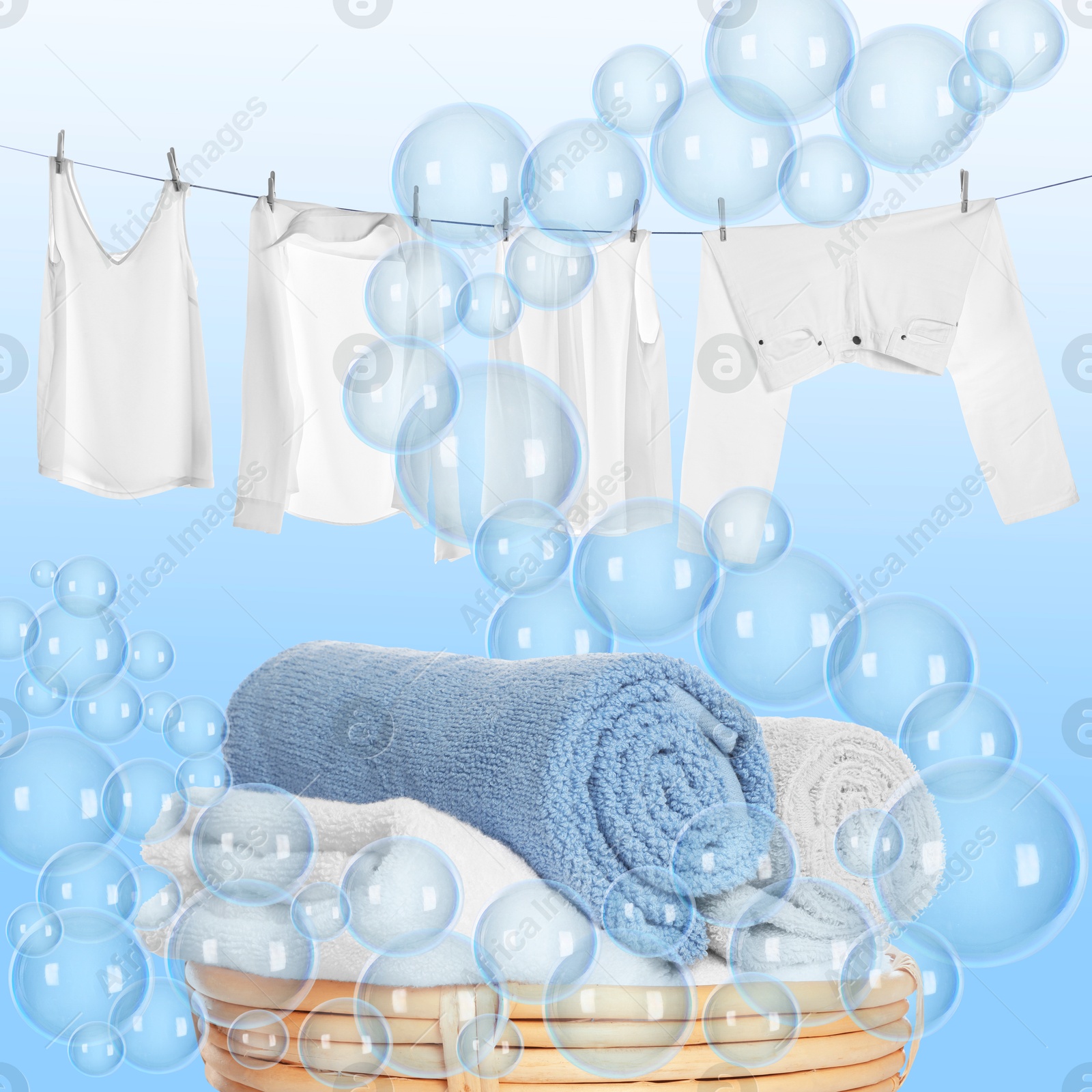 Image of Wicker basket with laundry and hanging on clothes rope garments among floating soap bubbles on light blue background