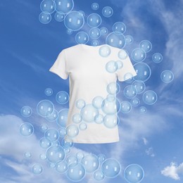 Image of T-shirt and floating soap bubbles in sky. Laundry day