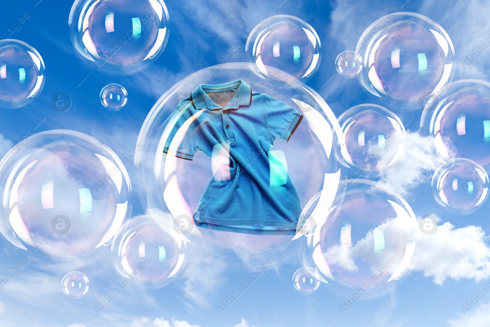 Image of One soap bubble with t-shirt inside and empty ones floating in sky. Laundry day