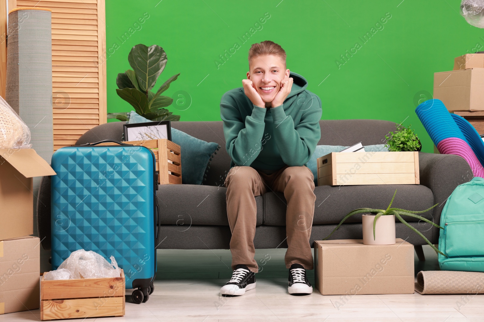 Photo of Happy man with different stuff in new apartment. Housewarming party