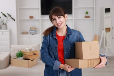 Photo of Happy woman with moving boxes in new apartment. Housewarming party