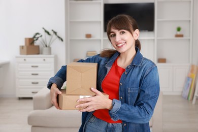 Photo of Happy woman with moving boxes in new apartment. Housewarming party