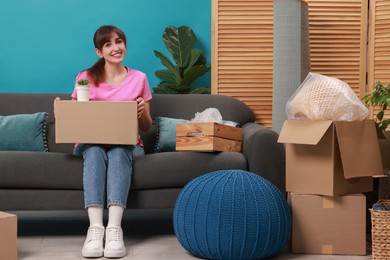 Photo of Happy woman with moving boxes in new apartment. Housewarming party