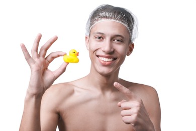 Photo of Happy man in shower cap with bath duck on white background