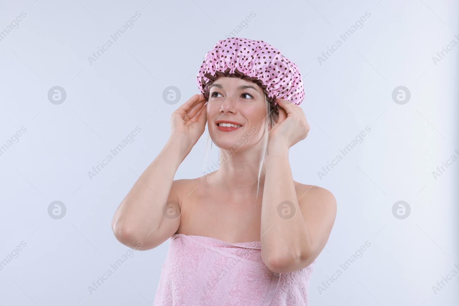 Photo of Woman wearing shower cap on white background