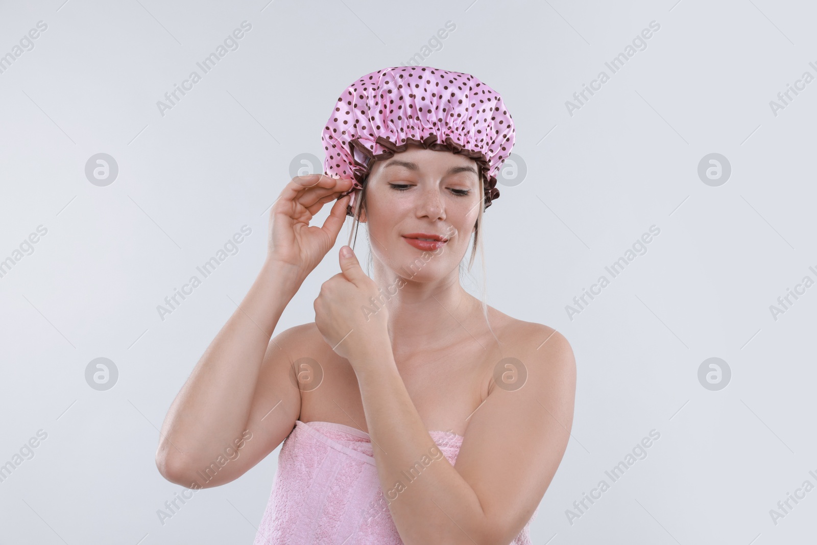 Photo of Woman wearing shower cap on white background