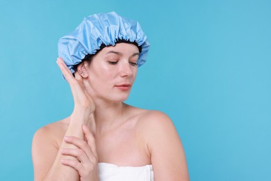 Photo of Woman wearing shower cap on light blue background