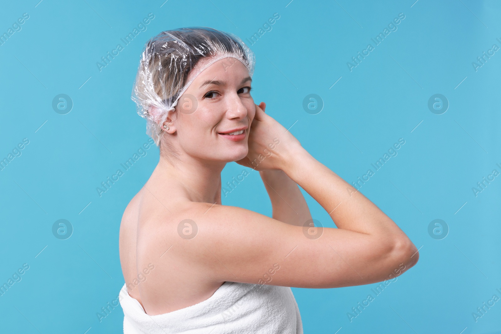 Photo of Woman in shower cap on light blue background