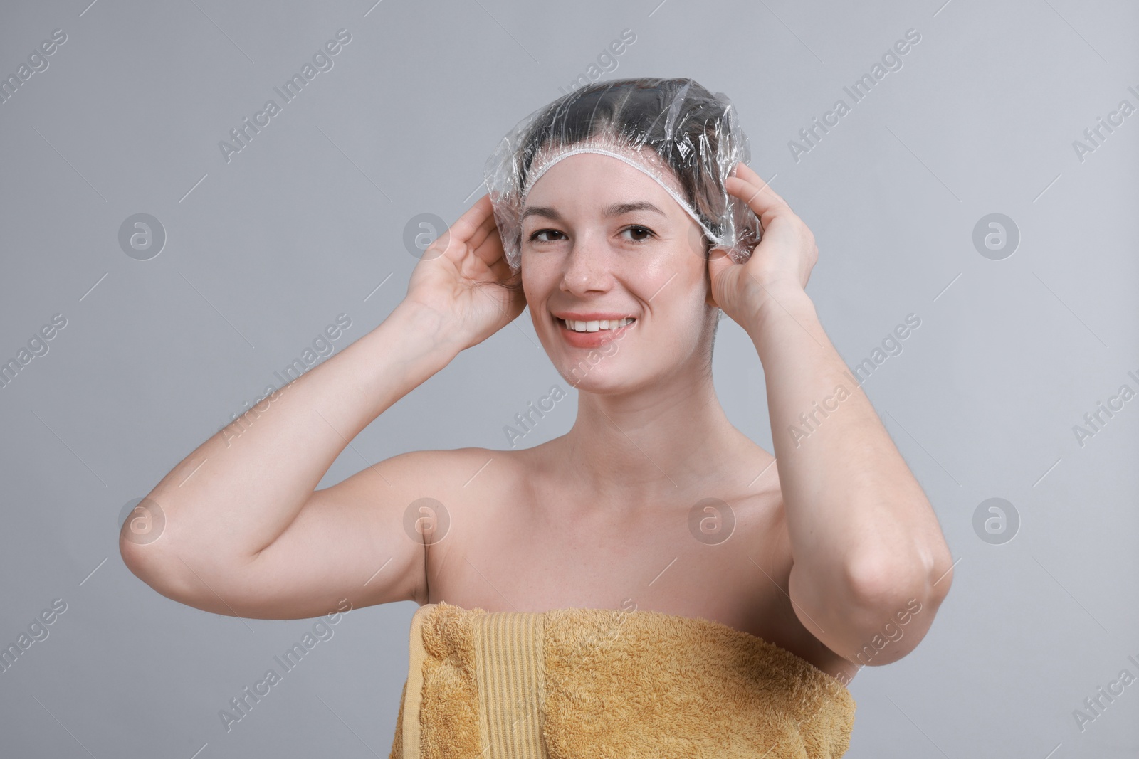 Photo of Woman wearing shower cap on grey background