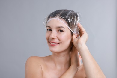 Photo of Woman wearing shower cap on grey background