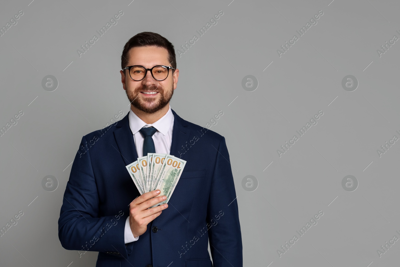 Photo of Portrait of banker with dollar banknotes on grey background