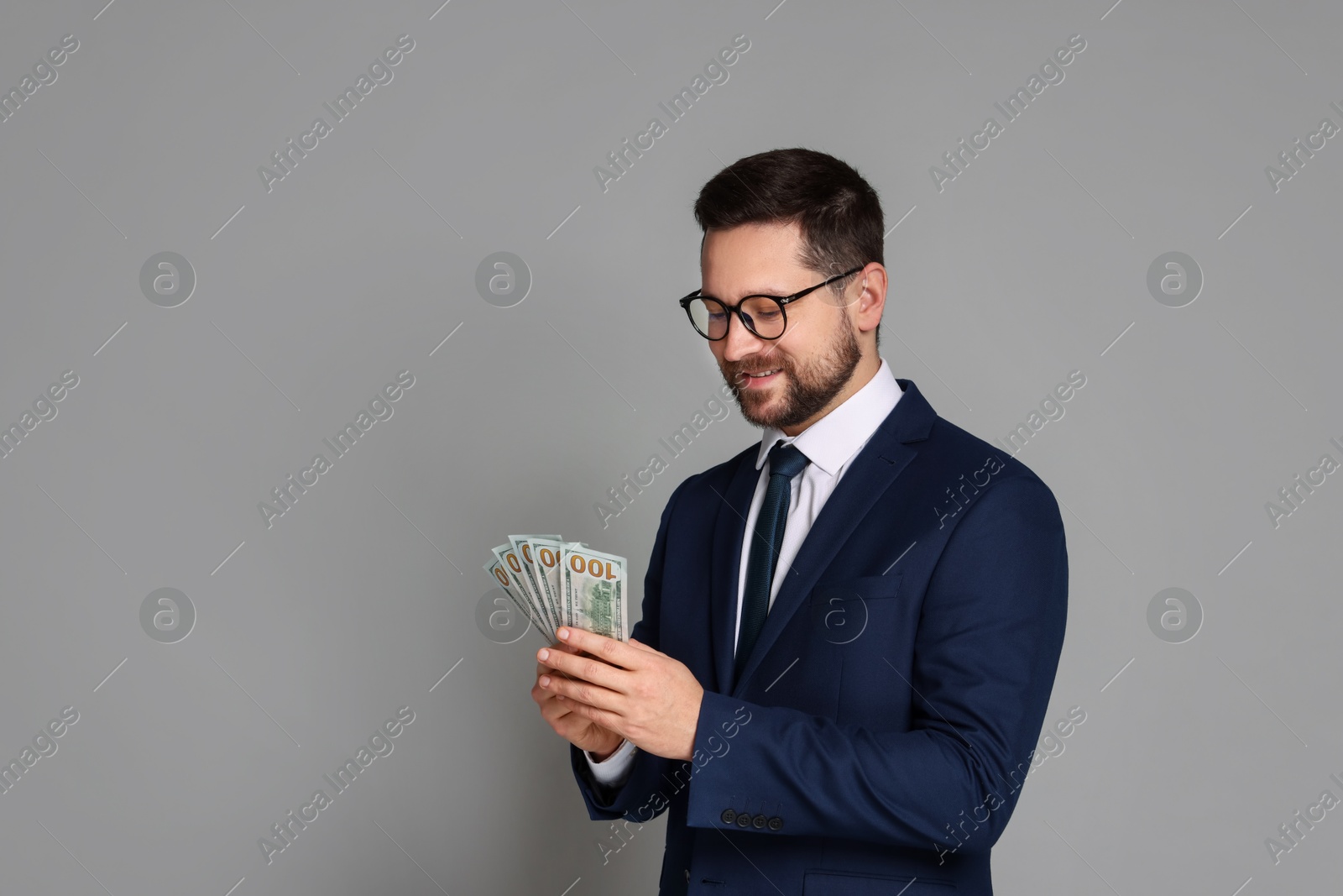 Photo of Portrait of banker with dollar banknotes on grey background, space for text