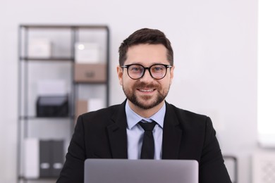 Photo of Portrait of banker using laptop in office