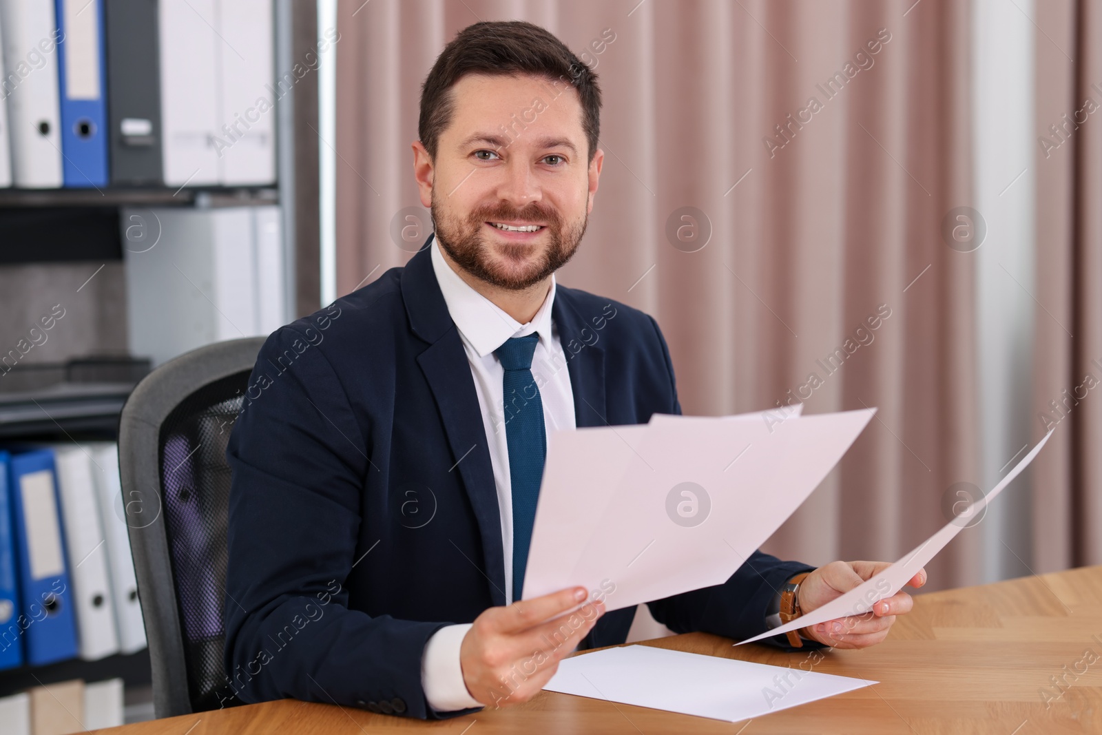 Photo of Banker working with documents at wooden table in office