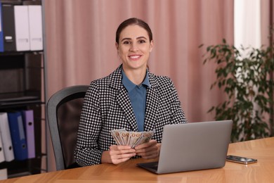 Photo of Banker with dollar banknotes at wooden table in office