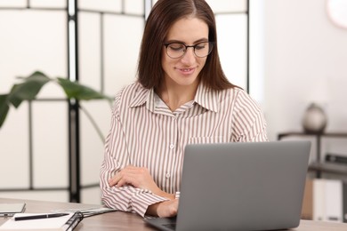 Photo of Banker working with laptop at table in office