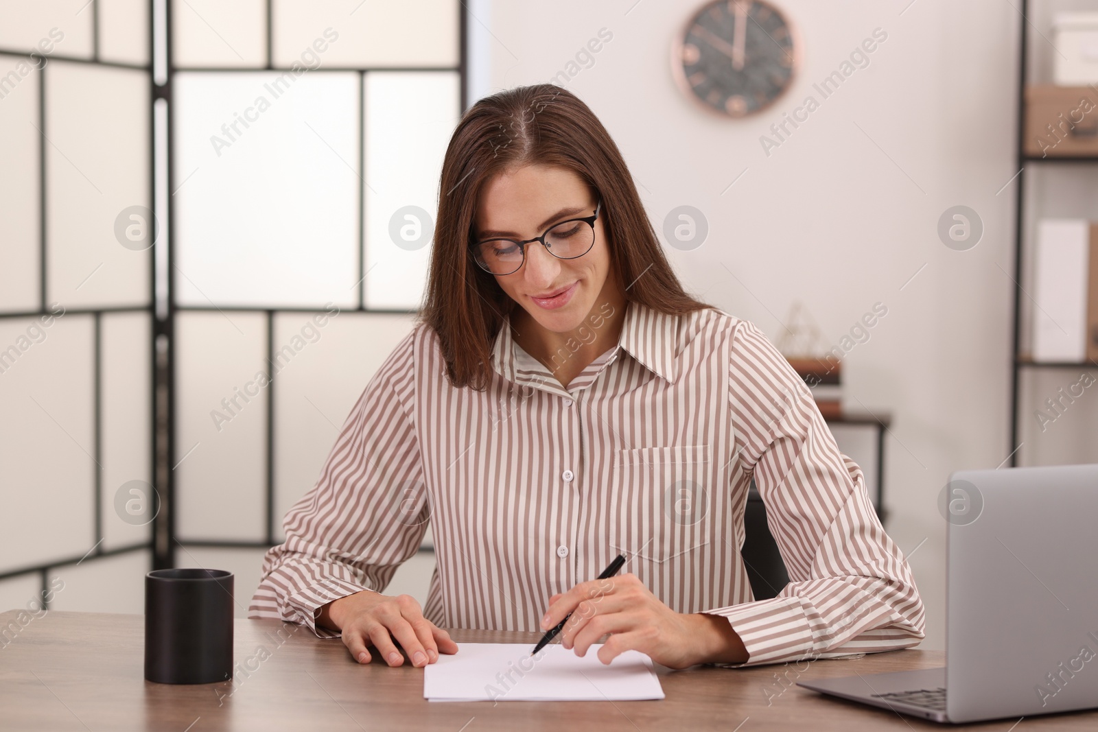 Photo of Banker working with document at wooden table in office