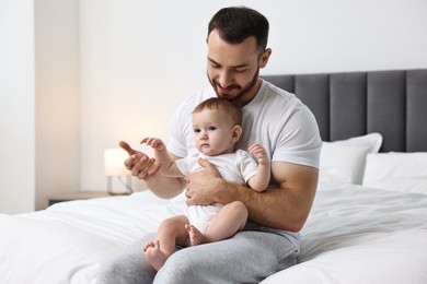 Father with his little baby on bed at home