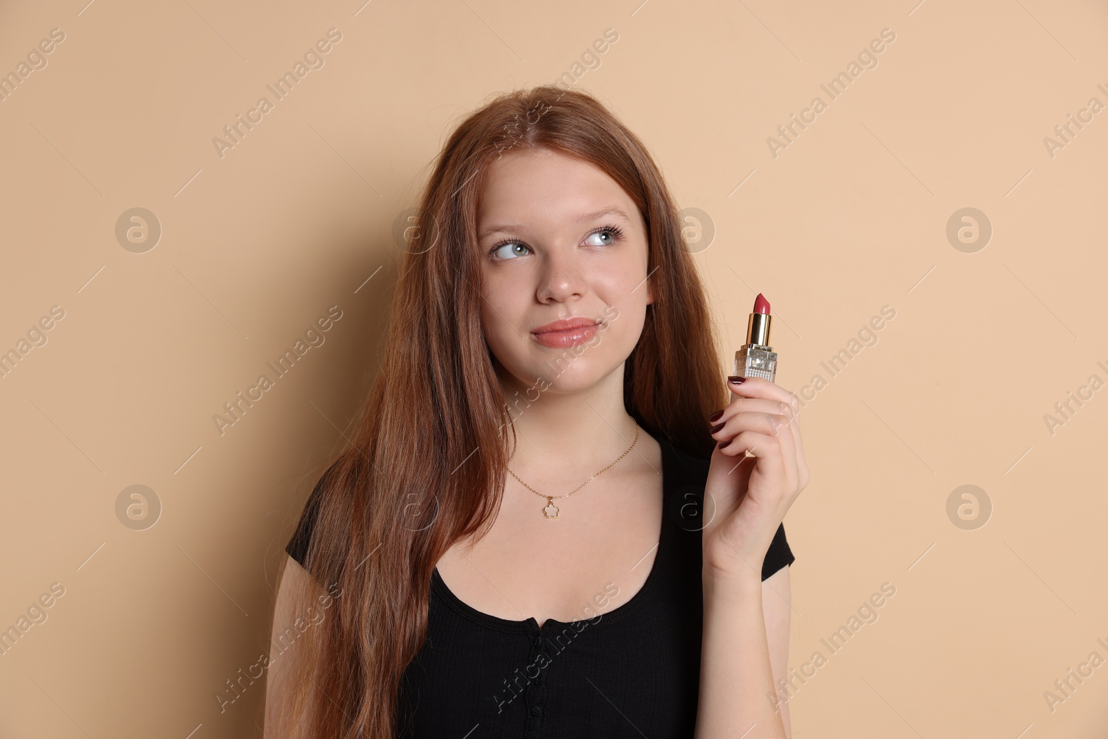 Photo of Teenage girl with lipstick on beige background