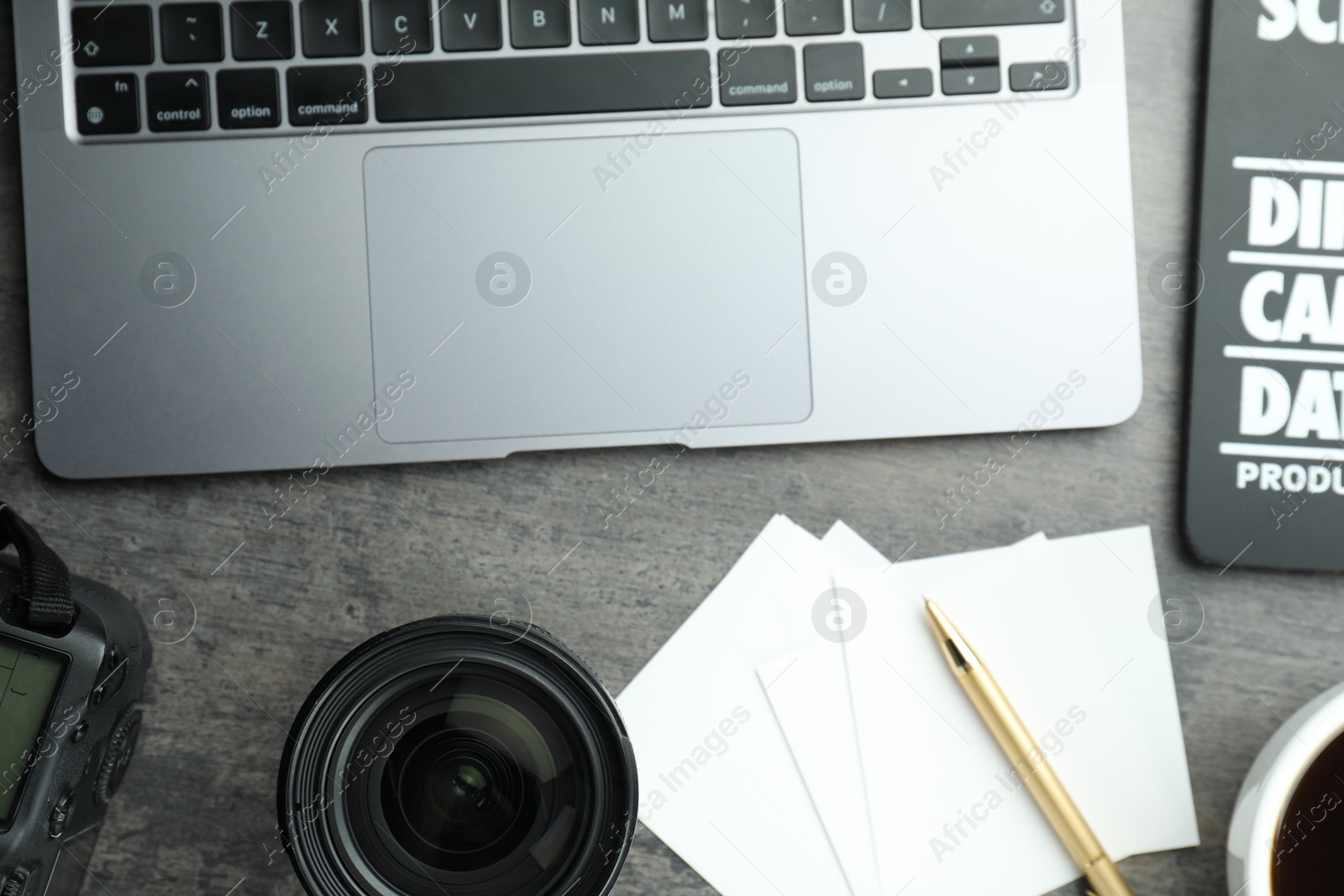 Photo of Flat lay composition with laptop and camera lens on grey textured table