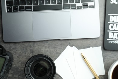 Photo of Flat lay composition with laptop and camera lens on grey textured table