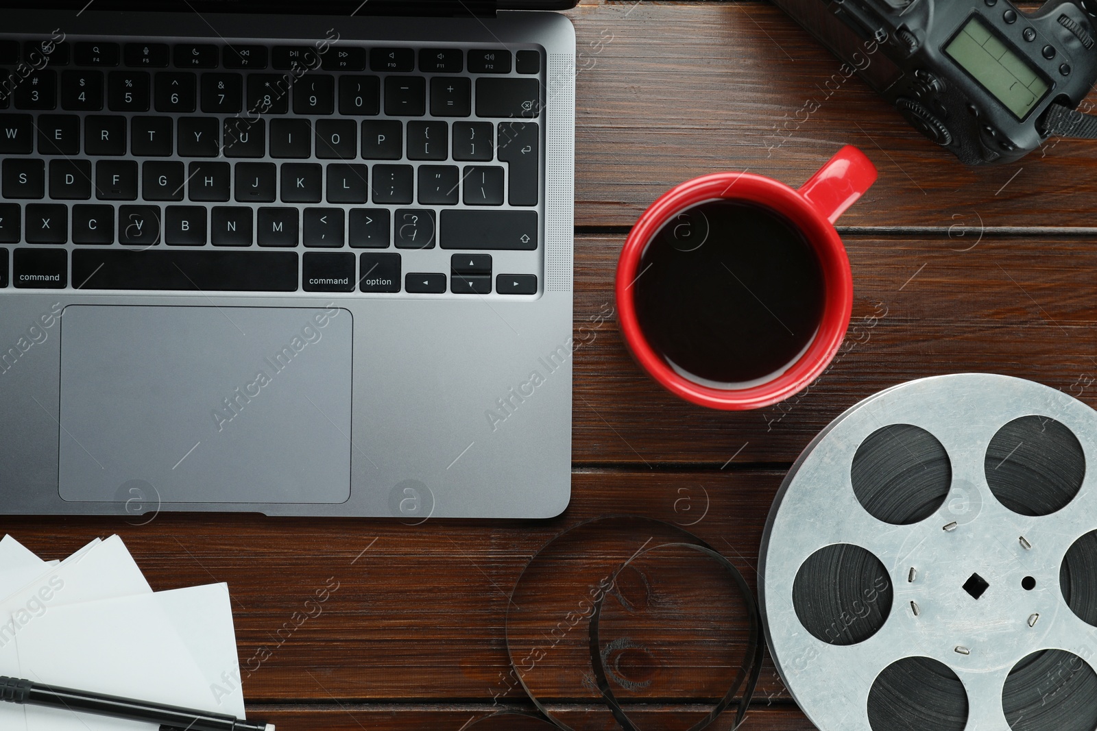 Photo of Flat lay composition with camera, film reel and laptop on wooden table