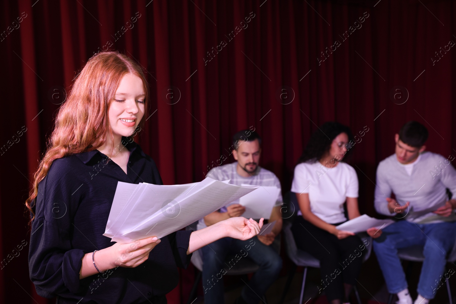 Photo of Professional actors reading their scripts during rehearsal in theatre