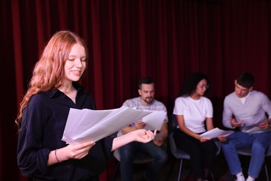 Professional actors reading their scripts during rehearsal in theatre