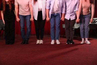 Photo of Professional actors bowing on stage in theatre, closeup