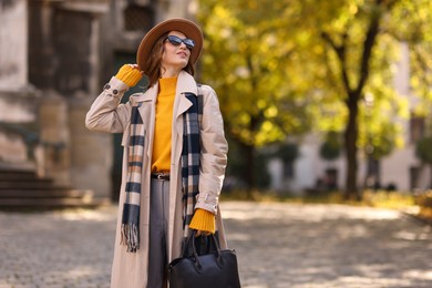 Photo of Charming young woman in stylish outfit on city street. Autumn season