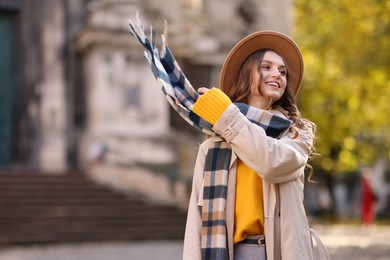 Charming young woman in stylish outfit on city street. Autumn season