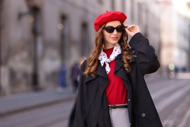 Photo of Charming young woman in stylish outfit on city street. Autumn season