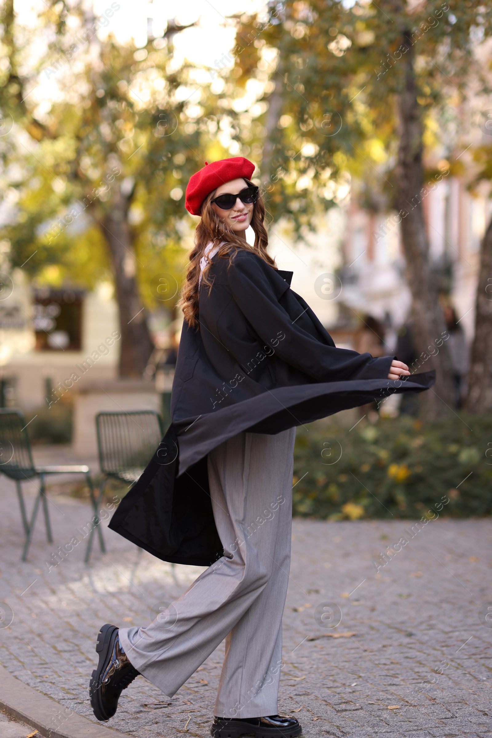 Photo of Charming young woman in stylish outfit on city street. Autumn season