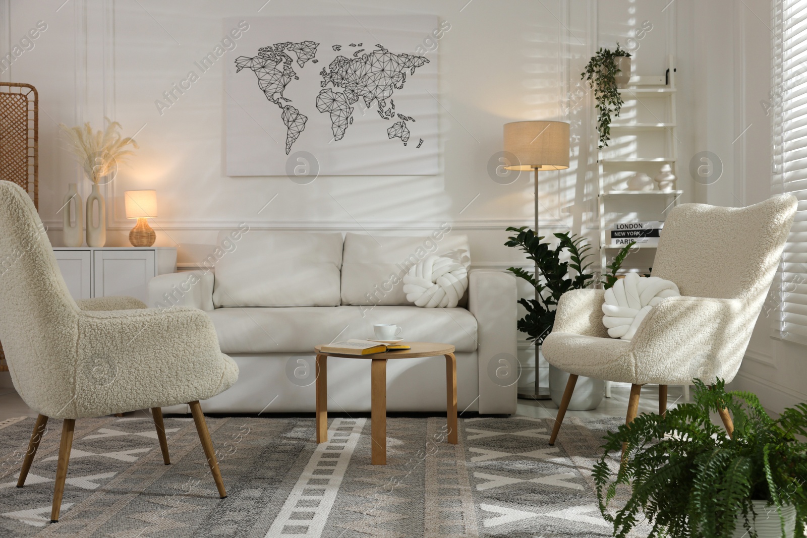 Photo of Soft armchairs, coffee table, sofa and houseplants in room