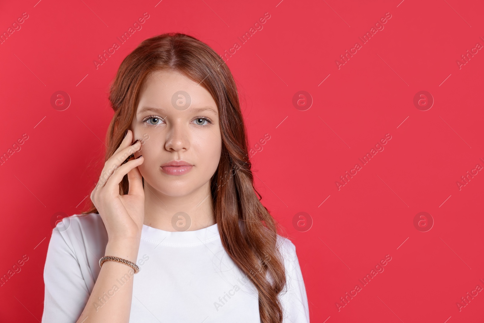 Photo of Portrait of beautiful teenage girl with natural makeup on red background. Space for text