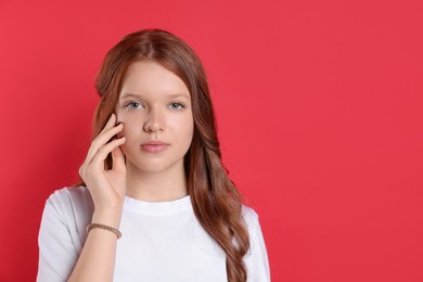 Photo of Portrait of beautiful teenage girl with natural makeup on red background. Space for text