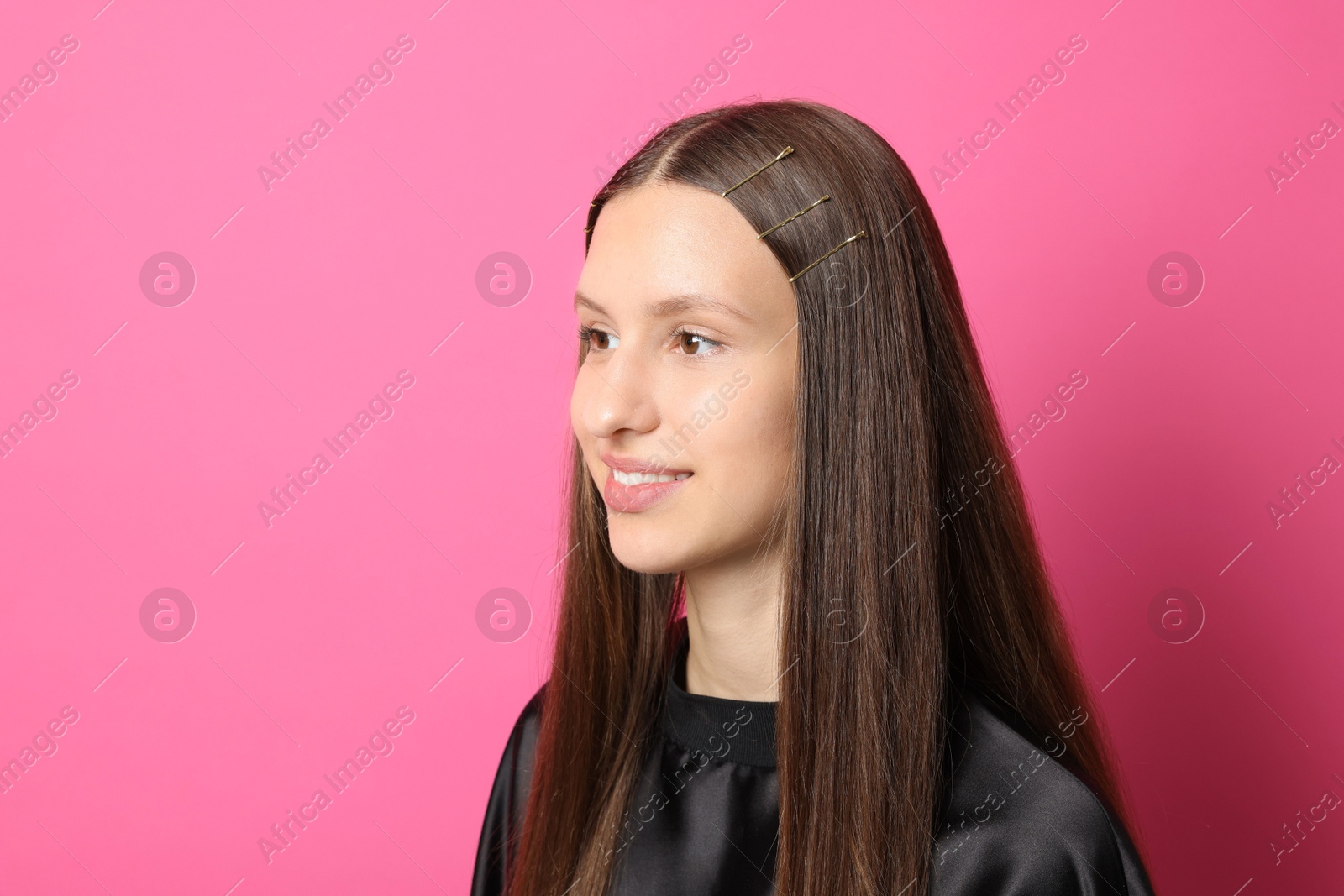 Photo of Teenage girl with stylish hair clips on pink background, space for text